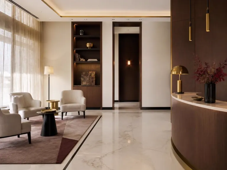 Hall intérieur d’un hôtel boutique parisien, marbre, bois, laiton et lumière naturelle douce